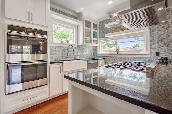An image of a modern kitchen with sleek appliances, featuring a gas stove, refrigerator, and built-in microwave in Sugar Land